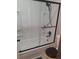Bathroom featuring a tub and shower combo with a black framed sliding glass door at 3550 S Harlan St # 313, Denver, CO 80235