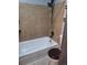 Full bathroom featuring a shower with a shower head, tiled walls, and toilet at 3550 S Harlan St # 313, Denver, CO 80235