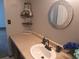 Bathroom vanity featuring decorative mirror, dark wood cabinets and tan counter at 3550 S Harlan St # 313, Denver, CO 80235