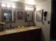 Bathroom with double sinks, granite countertops, framed mirrors, and stylish lighting fixtures at 3550 S Harlan St # 313, Denver, CO 80235
