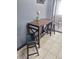 Charming dining area with a cozy table, stools, and access to outdoor space through a sliding door at 3550 S Harlan St # 313, Denver, CO 80235