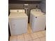 Bright laundry room with white washer and dryer set on tiled floor at 3550 S Harlan St # 313, Denver, CO 80235
