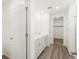 Bathroom featuring double sinks, vinyl flooring, and walk-in closet at 547 Homestead Ave, Brighton, CO 80601