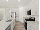 A bright kitchen featuring an island, granite counters, stainless steel appliances, and stylish gray cabinets at 547 Homestead Ave, Brighton, CO 80601