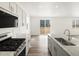 A bright kitchen featuring granite counters and stainless steel appliances next to the living room at 547 Homestead Ave, Brighton, CO 80601