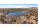 Breathtaking aerial view of a neighborhood showcasing a large lake, community pool, and mountain views at 8699 Garrison Ct, Arvada, CO 80005