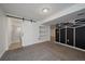 Finished basement with a barn door leading to a bathroom and a black and white wall design adding a unique touch at 8699 Garrison Ct, Arvada, CO 80005