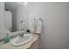 Half bathroom features stylish oval mirror and decorative hand towels at 8699 Garrison Ct, Arvada, CO 80005