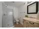 This bathroom features a glass shower, a toilet, a sink, and a square framed mirror at 8699 Garrison Ct, Arvada, CO 80005