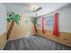 Bedroom with a ceiling fan, carpet flooring, window, and a palm tree mural design, offering a playful and tropical feel at 8699 Garrison Ct, Arvada, CO 80005