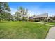 Charming home featuring a well-manicured front lawn and lush green trees at 8699 Garrison Ct, Arvada, CO 80005