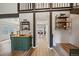 Hallway featuring hardwood floors, built-in shelving, and an open view to the dining area at 8699 Garrison Ct, Arvada, CO 80005