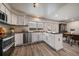 Bright kitchen featuring white cabinets, black countertops, stainless steel appliances, and eat-in dining area at 8699 Garrison Ct, Arvada, CO 80005