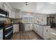 Updated kitchen with modern appliances, white cabinets, and stainless steel sink at 8699 Garrison Ct, Arvada, CO 80005