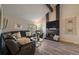 Cozy living room featuring a stone fireplace, large windows, and comfortable furnishings at 8699 Garrison Ct, Arvada, CO 80005