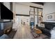 Open-concept living room with vaulted ceilings, sleek hardwood floors, and a cozy fireplace at 8699 Garrison Ct, Arvada, CO 80005