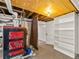 Basement with open ducts and water heater leading to a small bonus area with white bookshelf at 1528 Holly St, Denver, CO 80220
