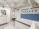 Updated bathroom with black and white tiles, tub with blue mosaic details, and white storage cabinet at 1528 Holly St, Denver, CO 80220