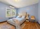 This bedroom features hardwood floors, large windows, and a queen-size bed with cozy linens at 1528 Holly St, Denver, CO 80220