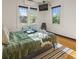 Cozy bedroom showcasing three windows, natural light, hardwood floors, and a comfortable setting with a view at 1528 Holly St, Denver, CO 80220