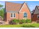Side view of a brick home with a well-maintained lawn and a large, unique arched window at 1528 Holly St, Denver, CO 80220
