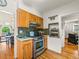 This kitchen features wood cabinets, stainless steel appliances, and a view into the dining room at 1528 Holly St, Denver, CO 80220