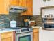 This kitchen features wood cabinets, a stainless steel stove and oven, and stylish backsplash at 1528 Holly St, Denver, CO 80220