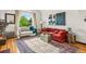 Bright living room featuring hardwood floors, vintage rug, curved window, and a comfortable seating arrangement at 1528 Holly St, Denver, CO 80220