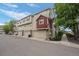 View of townhomes featuring attached garages, stone accents, and well-maintained landscaping at 1464 Nemrick Pl, Castle Rock, CO 80109