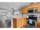 Open concept kitchen with wood cabinets and stainless steel appliances next to the dining area at 1464 Nemrick Pl, Castle Rock, CO 80109