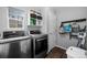 Laundry room with stainless steel washer and dryer, storage shelves, and hanging rack at 1464 Nemrick Pl, Castle Rock, CO 80109