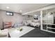 Finished basement with large sectional, carpet, and shelving for storage or display at 8895 E Radcliff E Ave, Denver, CO 80237