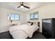 Comfortable bedroom featuring a bed, desk area, modern ceiling fan, and bright windows at 8895 E Radcliff E Ave, Denver, CO 80237