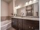 The bathroom boasts a double vanity, granite countertops, a soaking tub, and a separate tiled shower at 11250 Florence St # 17D, Commerce City, CO 80640