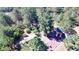 An aerial shot reveals a cute shed, surrounded by lush green trees, enhancing its secluded appeal at 12984 Crowfoot Springs Rd, Larkspur, CO 80118