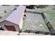 An aerial view shows a spacious outbuilding next to a fenced area and lush green grass at 12984 Crowfoot Springs Rd, Larkspur, CO 80118