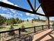 Relaxing covered back deck with a view of a vast green yard at 12984 Crowfoot Springs Rd, Larkspur, CO 80118