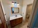 This bathroom has a wood vanity, sink with marble backsplash, and a view of the toilet through the doorway at 12984 Crowfoot Springs Rd, Larkspur, CO 80118