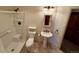 Bright bathroom features a shower/tub combo, pedestal sink, and neutral color palette at 12984 Crowfoot Springs Rd, Larkspur, CO 80118