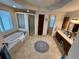 A spacious main bathroom featuring dual vanity sinks, a tub, and a separate shower at 12984 Crowfoot Springs Rd, Larkspur, CO 80118
