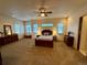 Spacious main bedroom with a ceiling fan, neutral walls, three windows, and carpet at 12984 Crowfoot Springs Rd, Larkspur, CO 80118