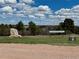 The Crowfoot Springs Ranch sign is in a grassy area surrounded by trees and other natural vegetation at 12984 Crowfoot Springs Rd, Larkspur, CO 80118