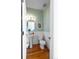 Charming half bathroom with wood floors, pedestal sink, and mint green walls at 211 Rockview Dr, Superior, CO 80027