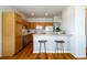 Eat-in kitchen featuring wood cabinets, breakfast bar, and stainless steel dishwasher at 211 Rockview Dr, Superior, CO 80027