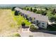 Rear view of a row of townhomes with well-maintained lawns, patios, and lovely trees at 211 Rockview Dr, Superior, CO 80027