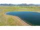 A scenic view of a tranquil lake surrounded by lush green fields, and mountains in the distance at 211 Rockview Dr, Superior, CO 80027