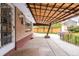 Outdoor back porch of brick house with a metal patio cover, patio, and landscaped yard at 5099 S Linden Dr, Englewood, CO 80110