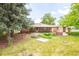 Beautiful backyard showcasing the brick home, patio, and mature trees at 5099 S Linden Dr, Englewood, CO 80110