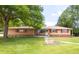 Charming brick home with a well-manicured lawn and a beautiful mature tree at 5099 S Linden Dr, Englewood, CO 80110