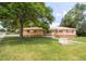 Charming brick home with a well-manicured lawn and a beautiful mature tree at 5099 S Linden Dr, Englewood, CO 80110